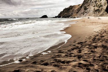 Cesur okyanus, kaya oluşumları ve bulutlu drama gökyüzü Sintra, Lizbon, Portekiz 'de Adraga sahillerinde