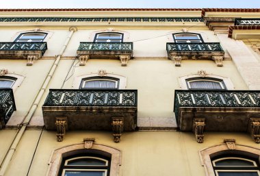 Baharda Lizbon sokaklarında eski renkli ve heybetli ön cephelerde klasik sokak lambaları.