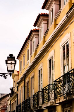 Baharda Lizbon sokaklarında eski renkli ve fayanslı ön cephelerde klasik sokak lambaları.