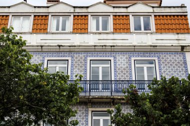 Baharda Lizbon sokaklarında eski renkli ve fayanslı ön cephelerde klasik sokak lambaları. Ön cephede çamaşır ipi asılı kıyafetlerle