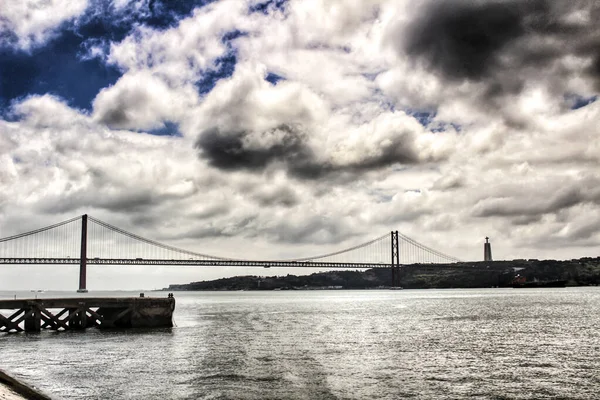 曇りの日に春にリスボンのタガス川の銀行 美しい25 4月橋構造 — ストック写真