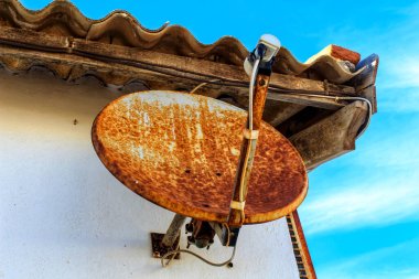 Old satellite dish in a house in Spain clipart