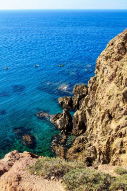 Cabo de GAta 'daki Sirenler resifi, Almerya, İspanya yazın güneşli bir gününde. Arka planda kano çalışması yapan insanlar..