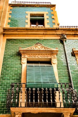 Elche, Alicante, İspanya 'da eski renkli ve görkemli ön cephelerde klasik sokak lambaları. El Raval Mahallesi.