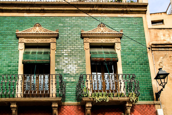Old colorful and majestic tiled facades with vintage streetlight in Elche, Alicante, Spain. El Raval neighborhood.