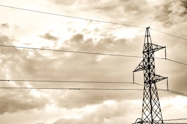 İspanya 'da bulutlu gökyüzünün altında elektrik hatları kulesi