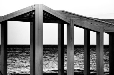 Kumsaldaki beyaz ahşap yapı. Arka planda Akdeniz.