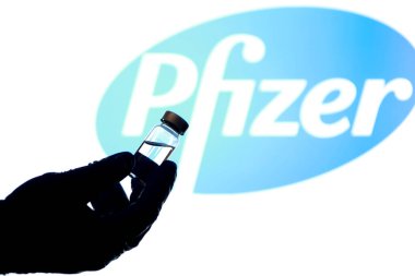 Madrid, İspanya - 2 Mayıs 2021: Beyaz arka planda covid-19 aşısı ve Pfizer laboratuvar logosu olan el ele tutuşma şişesi.
