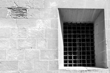 Elche, Alicante, İspanya 'daki Santa Maria Kilisesi' nin taş cephesinde dövülmüş demir parmaklıklı pencere.