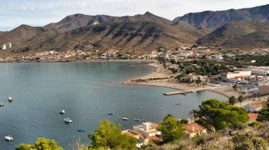 Güneşli bir günde İspanya, Murcia, Cartagena 'daki La Azohia köyünde kayalıkları ve dağları olan güzel bir sahil. Santa Elena kulesinden görüntüler.
