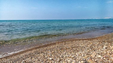 Güneşli bir günde İspanya, Murcia, Cartagena 'daki La Azohia köyünde tekneleri, uçurumları ve dağları olan güzel bir sahil.