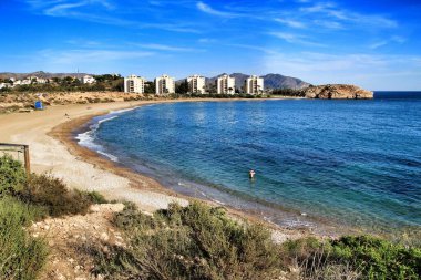 Isla Plana, Cartagena, Murcia, İspanya 'daki güzel Mojon plajı. Arkaplanda binalar.