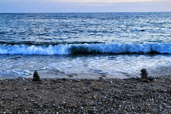 在卡塔赫纳日落时分 在平面岛上的海滩上堆放了几块石头 背景中的波浪 — 图库照片