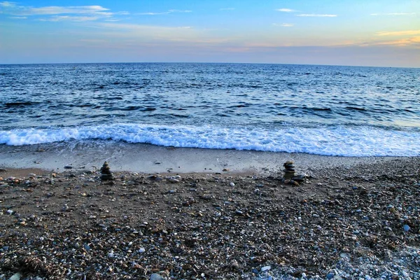 在卡塔赫纳日落时分 在平面岛上的海滩上堆放了几块石头 背景中的波浪 — 图库照片