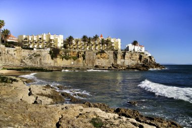 Güneşli bir kış gününde Estoril, Lizbon, Portekiz 'de kaya oluşumları olan güzel Azarujinha plajı.