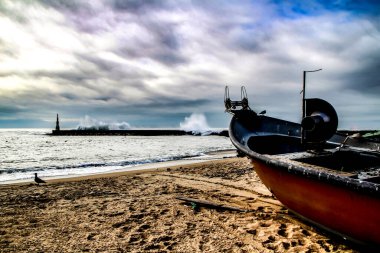 Balıkçı tekneleri Aguda sahilinde karaya oturmuş dalgalar dalgaları kırıyor dalgalar ve deniz feneri Aguda sahilinde