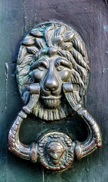 Vintage door knocker on green wooden door in Portugal