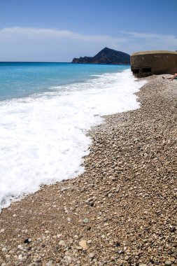 Altea, Alicante, İspanya 'da güneşli bir bahar gününde Cap Negret plajı ve Sivil Savaş sığınağı.