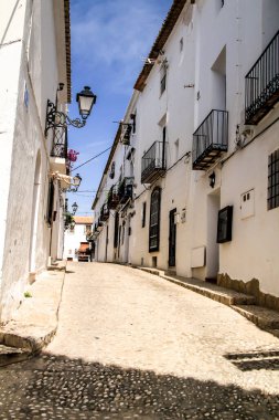 Altea, Alicante, İspanya - 12 Haziran 2021: Dar sokaklar ve tipik beyazlatılmış cepheler Altea köyü, Alicante, İspanya