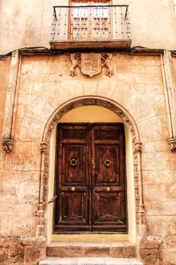 Alcaraz, Albacete, İspanya 'da görkemli bir evde oyma taş ve eski ahşap kapılardan yapılmış eski taş cephe..