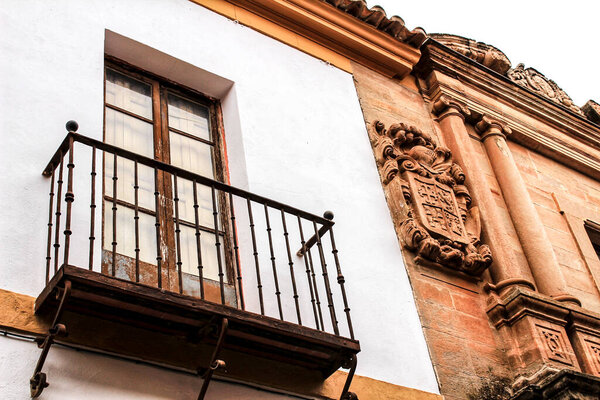 Old stone facade made of carved stone and vintage wooden door in a majestic house in Villanueva de los Infantes, Ciudad Real community, Spain