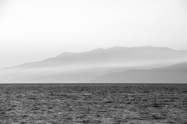 Öğleden sonra Cabo de Gata, Almeria, İspanya 'daki Salinas plajında. Arkadaki sisli dağlar. Tek renkli resim.
