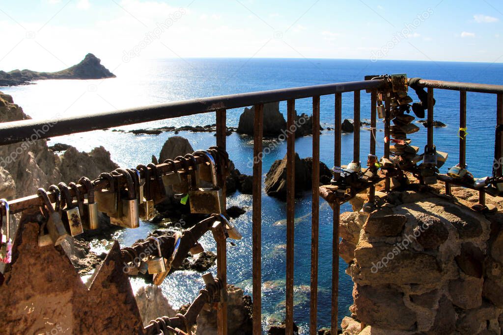 Romantic padlocks hanging on The Reef of the Sirens railing in Cabo de Gata-Nijar, Almeria, Spain
