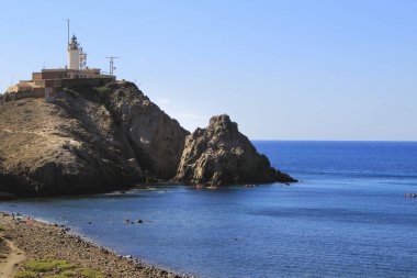 Güzel Corralete plajı ve arka planda Cabo de Gata deniz feneri güneşli bir yaz gününde