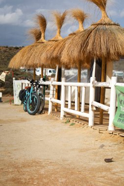 Pulpi, Almeria, İspanya... 11 Ekim 2025: Yalnız bar terasında iki mavi bisiklet ve Almerya, İspanya 'da Los Cocedores plajında cıvıltı