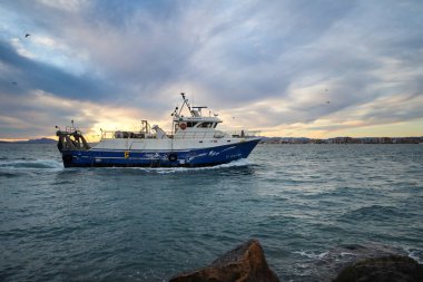 Santa Pola, Alicante, İspanya... 26 Kasım 2025, Santa Pola limanına gün batımında dönen balıkçı teknesi.