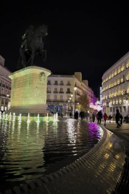 Madrid, İspanya - 7 Aralık 2025 King Charles III heykeli ve gece Puerta del Sol meydanı