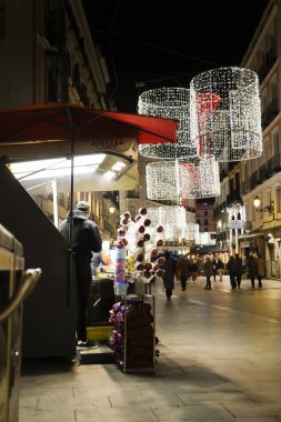 Madrid, İspanya - 7 Aralık 2025: Carmen caddesinde şeker tezgahı gece Madrid 'de Noel süsüsüyle
