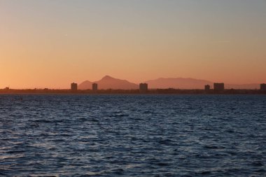 San Pedro del Pinatar kasabasındaki Calcetera değirmeninden Mar Menor 'da güzel bir günbatımı, Murcia, İspanya