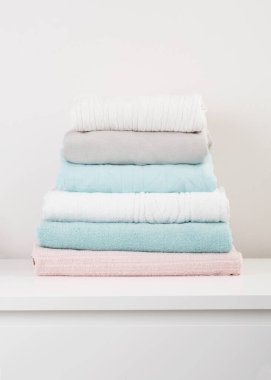 Yatak odasındaki şifoniyerin üzerinde bir yığın temiz, yıkanmış elbise.