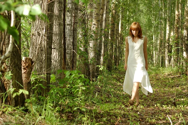 Kobieta w białej sukni, spacery po jednym w drewnie — Zdjęcie stockowe