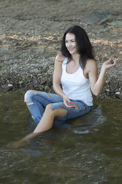 Flickan kastar stenar i vatten — Stockfoto