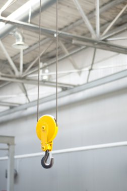 Bir depoda çalışan vincin sarı kanca