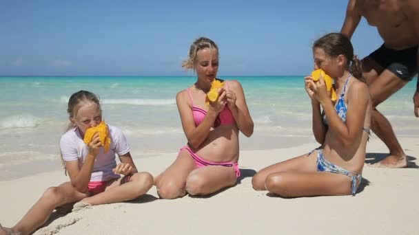 Família na praia comendo manga fruta — Vídeo de Stock