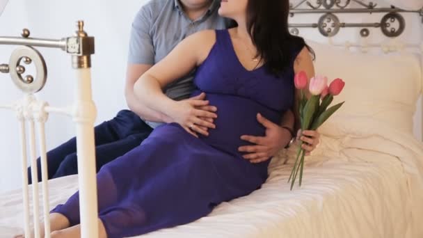 Femme enceinte avec son mari sur le lit . — Video