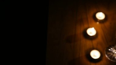 Şarap, gözlük ve yanan mumlar.