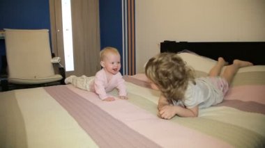 Çocuk ve yeni doğan kardeşi yatakta