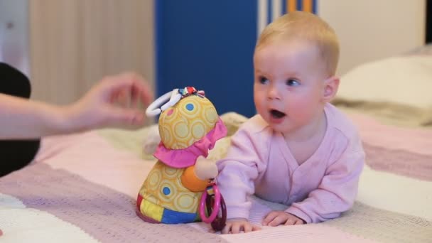 Baby met een stuk speelgoed. — Stockvideo