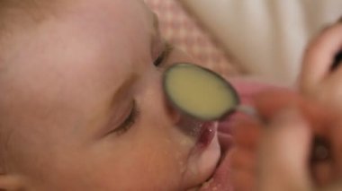 Anne bebeğini kaşık ile besleme.