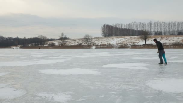 Padre con hija patinaje sobre hielo en el lago congelado — Vídeos de Stock