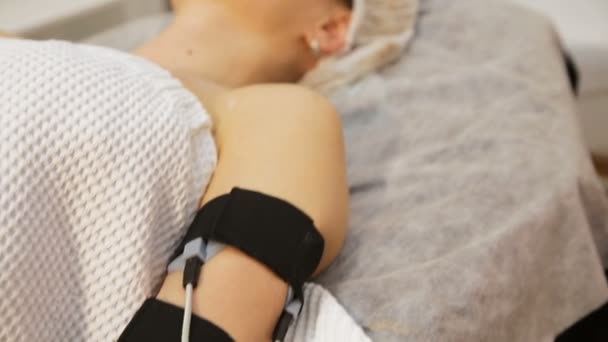 Kvinna med electro stimulator elektroder på hennes kropp. — Stockvideo