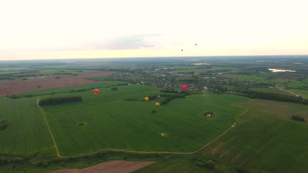 Θερμού αέρα μπαλόνια στον ουρανό πάνω από ένα πεδίο. Εναέρια άποψη — Αρχείο Βίντεο