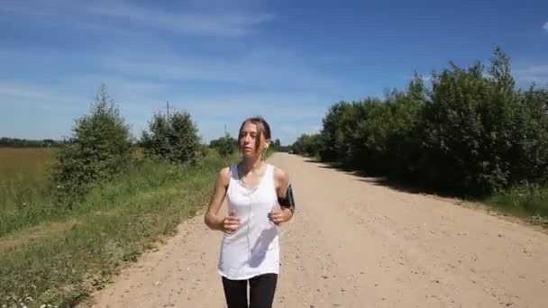 Meisje loopt op de weg in een veld. — Stockvideo
