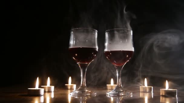 Weingläser und brennende Kerzen im Rauch. — Stockvideo