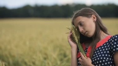 Güzel genç genç kız buğday buğday alanında kulaklı.