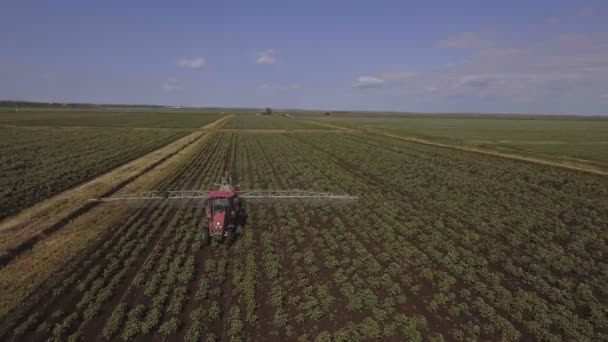 Трактор обприскує добрива картопляним полем. Повітряне відео . — стокове відео